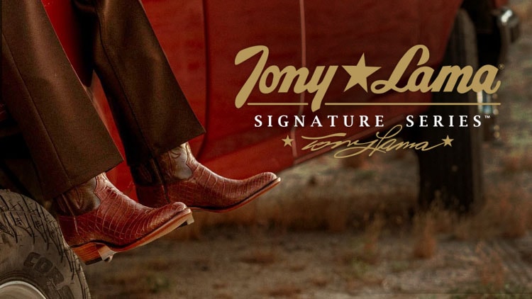 A man wearing a pair of Signature Series boots sitting on a red truck.